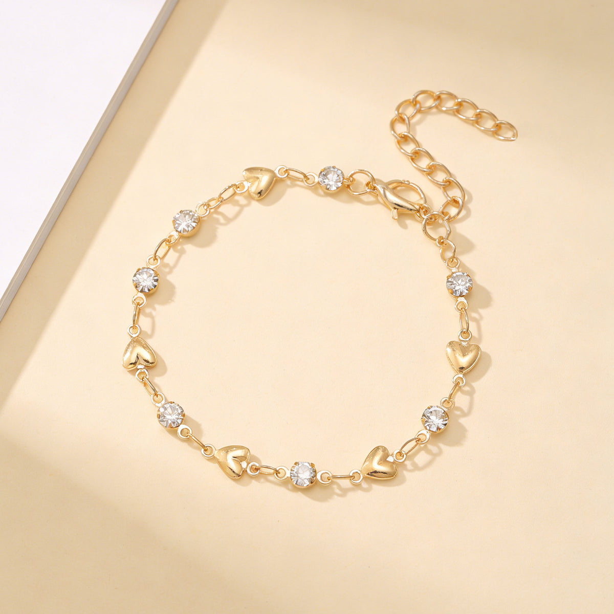 Venus Heart Bracelet in gold — polished hearts and clear stones with extender chain